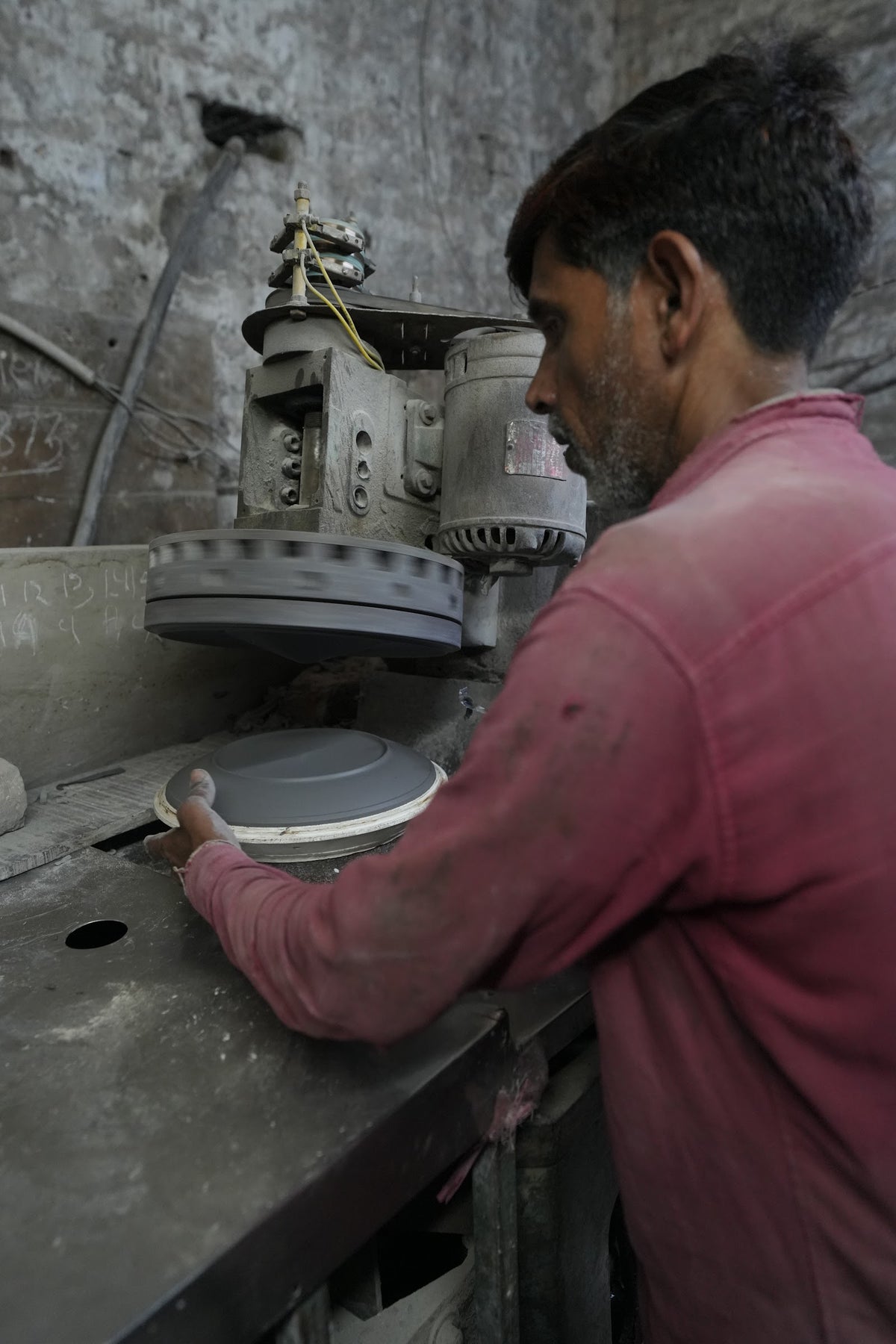 An artisan shaping a ceramic plate by hand on a spinning wheel